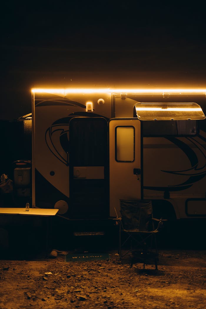 A dimly lit camper van with outdoor gear evokes adventure travel under a moody night sky.